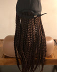 Mannequin with Coils to Locs kimmie cap braids in brown back view, black cap.