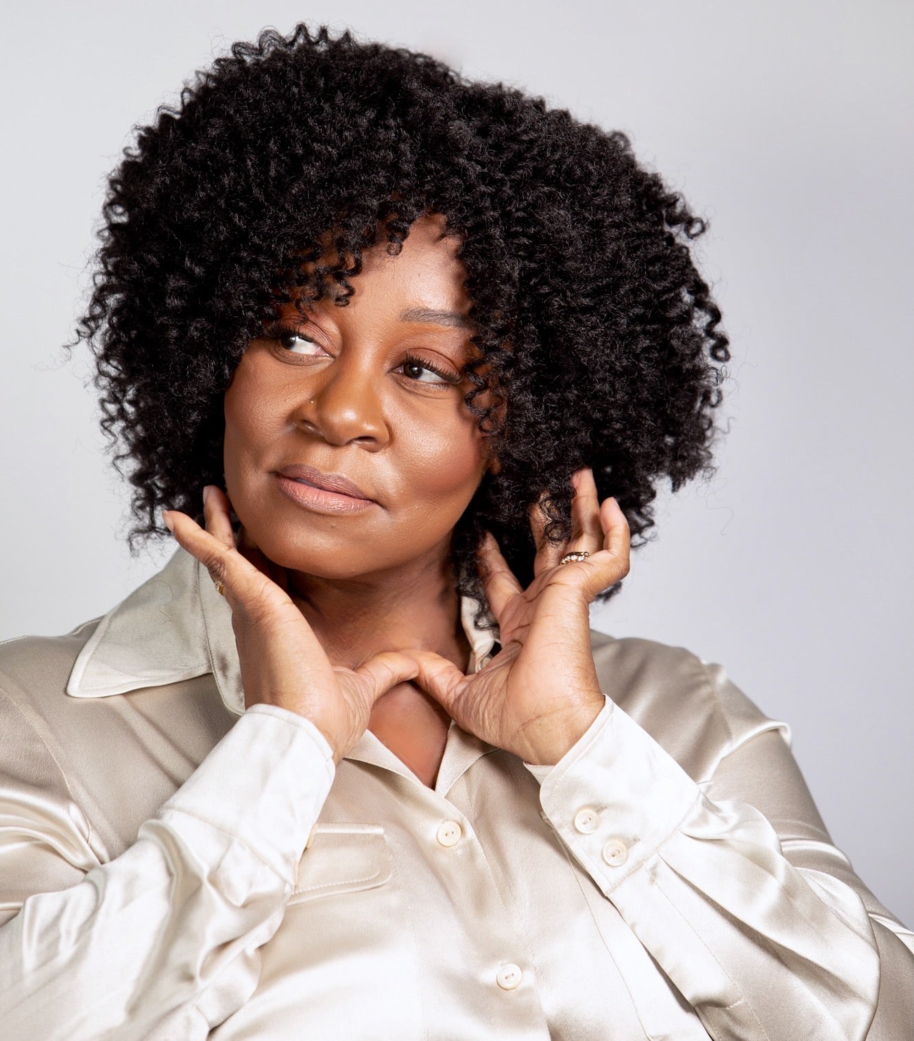 Black woman wearing Coils to Locs Ashanti wig in black.