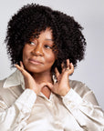 Black woman wearing Coils to Locs Ashanti wig in black.