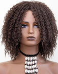 Coils to Locs Imani wig dark brown front with mannequin wearing cowerie shell necklace.