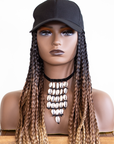 Mannequin with a Coils to Locs kimmie cap 18" ombre braids, black cap, cowerie shell necklace.